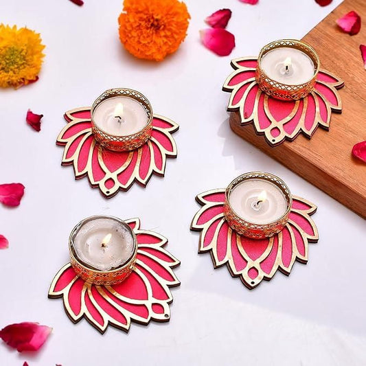 Decorative candle holders with pink and gold designs on a white surface with flowers and petals.